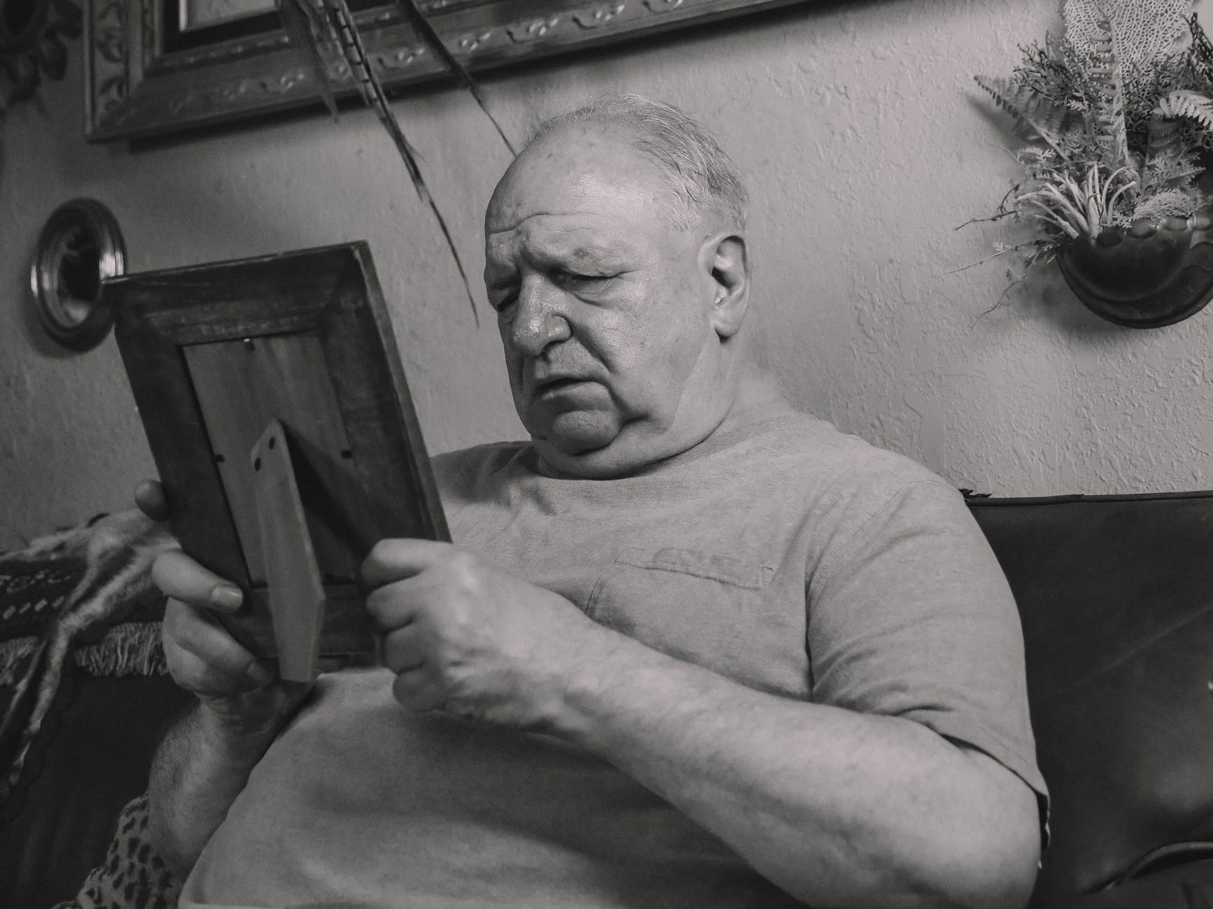 aged care in Australia on the menu- a grayscale photo of an elderly man holding a wooden frame