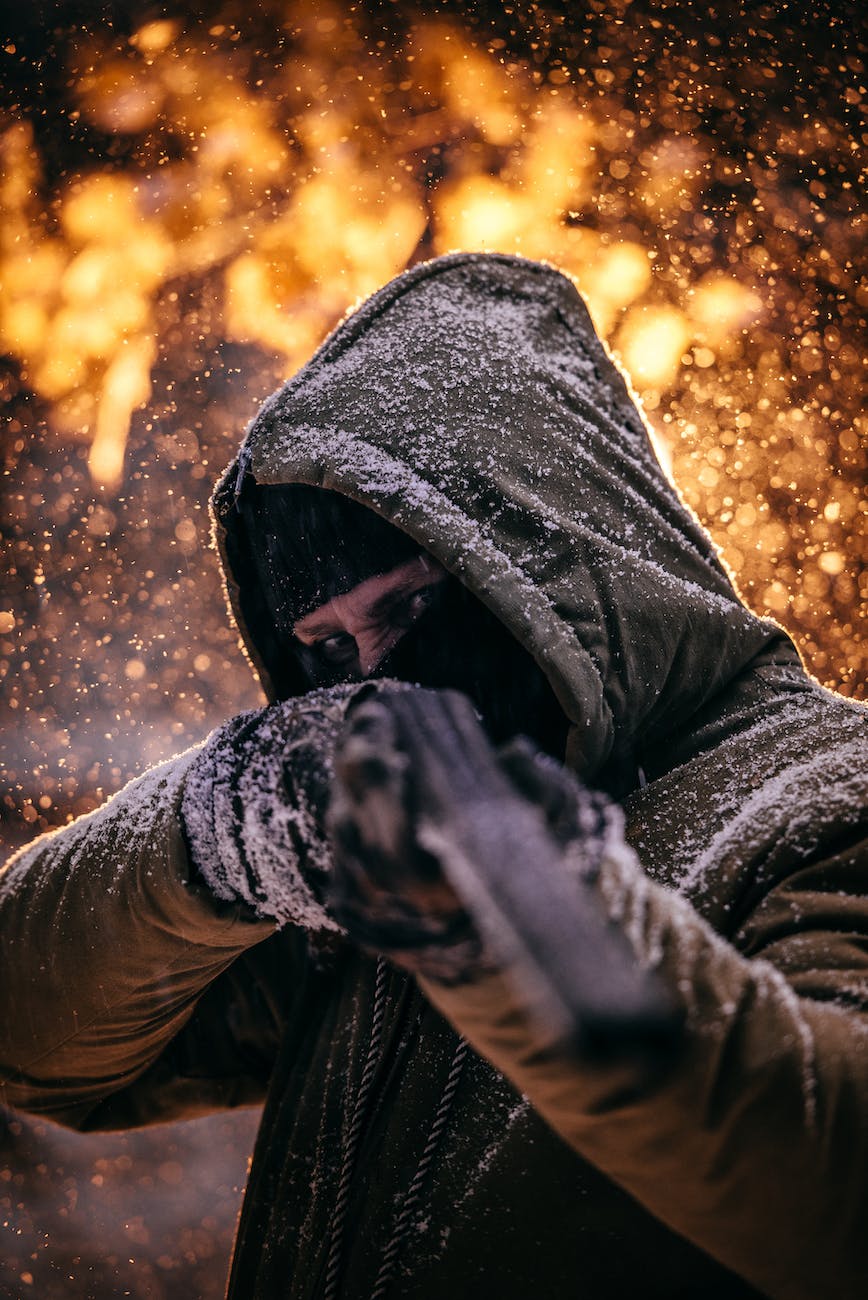 shallow focus photo of person wearing gray hoodie holding black rifle