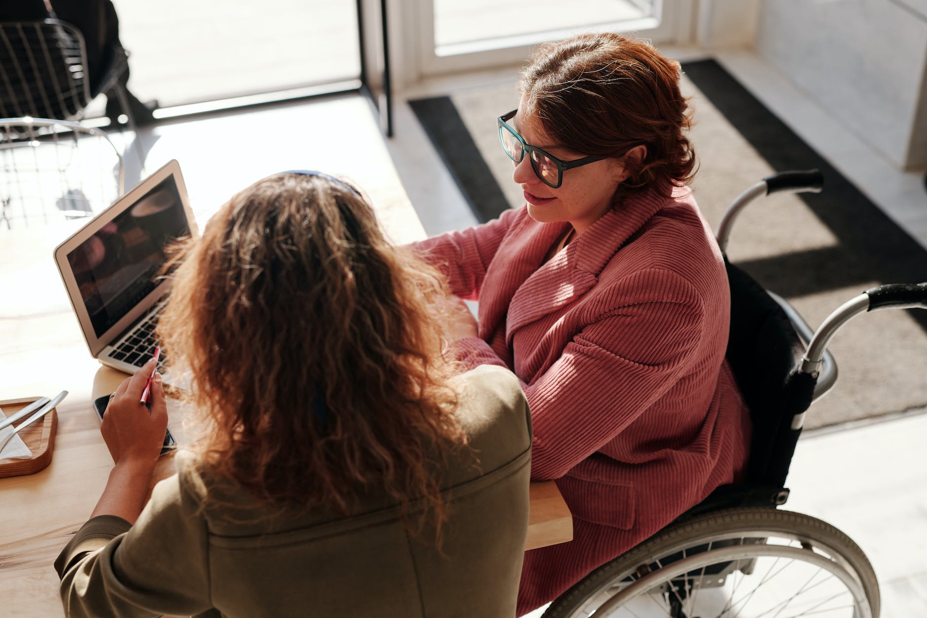 woman in red sweater wearing black framed eyeglasses sitting on wheelchair