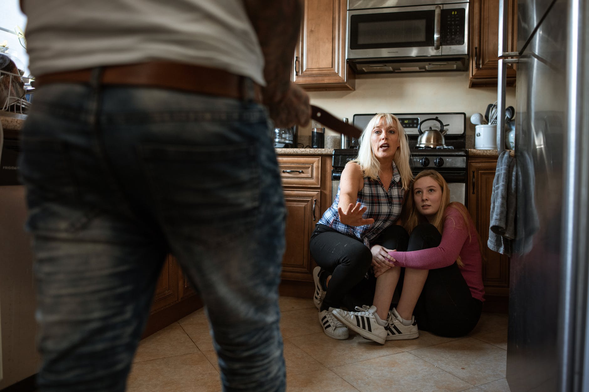 a scared mother and daughter in a kitchen