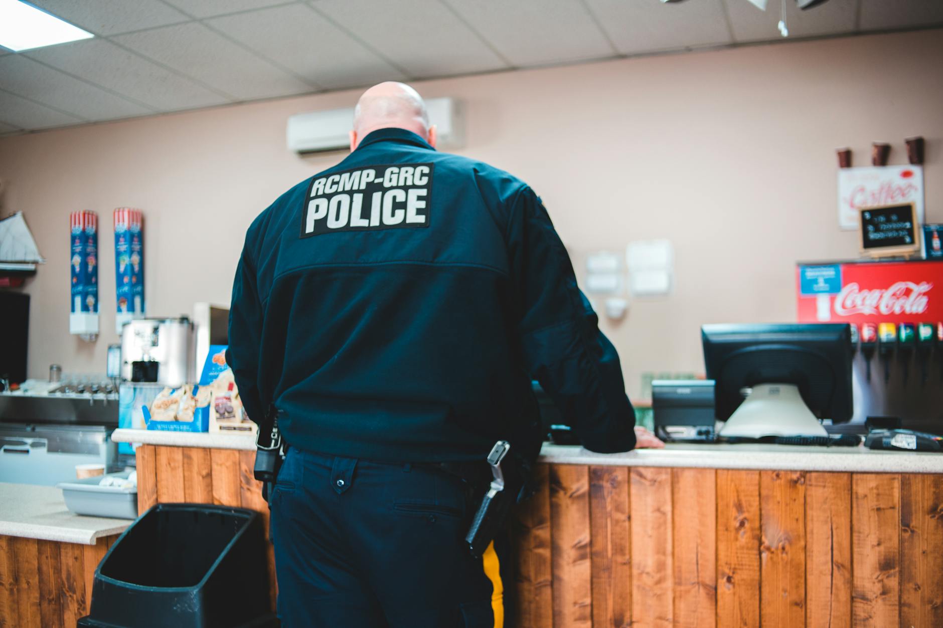 police man standing infront of a counter in a restaurant