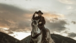 2 men riding horses on grass field during daytime
